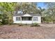 Charming single-story home with a screened-in porch and mature landscaping at 9025 Gronde Ave, Brooksville, FL 34601