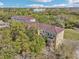 Aerial view of complex surrounded by mature trees with tile roofs at 958 Sombra St, Tampa, FL 33619