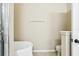 Minimalist bathroom featuring a soaking tub with a white towel and a matching toilet for cleanliness at 958 Sombra St, Tampa, FL 33619