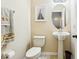Charming powder room with pedestal sink, decorative mirror, and neutral color scheme at 958 Sombra St, Tampa, FL 33619
