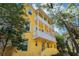 Inviting three-story yellow townhome with dual-level balconies and lush landscaping at 958 Sombra St, Tampa, FL 33619