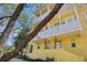 Welcoming three-story yellow townhome featuring dual-level balconies and covered entrances at 958 Sombra St, Tampa, FL 33619