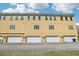 Rear exterior view of the townhome featuring multiple garage doors and ample parking space at 958 Sombra St, Tampa, FL 33619
