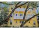 Charming yellow townhome with double balconies and shade trees at 958 Sombra St, Tampa, FL 33619