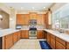 Well-equipped kitchen with wooden cabinets, stainless steel appliances, and tiled backsplash at 958 Sombra St, Tampa, FL 33619