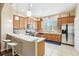 Modern kitchen with stainless steel appliances, tile backsplash, and a breakfast bar with white stools at 958 Sombra St, Tampa, FL 33619