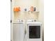 Functional laundry room featuring a washer and dryer with storage shelves at 958 Sombra St, Tampa, FL 33619