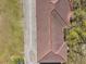 Close up aerial view of a brown tile roof surrounded by grass and trees at 958 Sombra St, Tampa, FL 33619