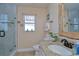 Bright bathroom features a shower with glass doors and a granite vanity with decorative mirror at 10222 Woodford Bridge St, Tampa, FL 33626