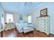 Bright bedroom with vaulted ceiling, hardwood floors, floral bedding, and plentiful natural light at 10222 Woodford Bridge St, Tampa, FL 33626