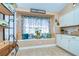 Sunlit breakfast nook with window seat, white cabinets, and view of the kitchen with tile flooring at 10222 Woodford Bridge St, Tampa, FL 33626