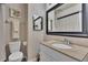 Bathroom featuring a toilet, sink, mirror, and shower with neutral color walls at 11308 Grandville Dr, Temple Terrace, FL 33617