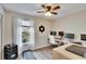 Bright bedroom with a ceiling fan, large window, and a desk with computer setup at 11308 Grandville Dr, Temple Terrace, FL 33617