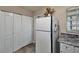 Cozy kitchen area with white appliances, cabinetry, and tile flooring at 11308 Grandville Dr, Temple Terrace, FL 33617
