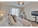 Bright main bedroom featuring a TV, closet, and large window with curtains at 11308 Grandville Dr, Temple Terrace, FL 33617