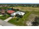 Aerial view of residence with a manicured lawn in a residential community at 12 Medalist Ter, Rotonda West, FL 33947