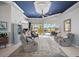 Bright living room with tile flooring, comfortable seating, blue accent ceiling, and sliding glass doors to the lanai at 12 Medalist Ter, Rotonda West, FL 33947