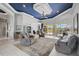 Spacious living room with plush seating, tile flooring, eye-catching ceiling, and access to the outdoor area at 12 Medalist Ter, Rotonda West, FL 33947