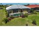 Aerial view of pool and lanai surrounded by beautiful landscaping in backyard at 12 Medalist Ter, Rotonda West, FL 33947