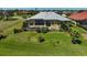Wide aerial view of a pool and lanai surrounded by beautiful landscaping in backyard at 12 Medalist Ter, Rotonda West, FL 33947