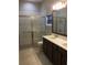 Bathroom featuring double sink vanity, large shower with glass door, and contemporary finishes at 1214 Godavari Way, Wesley Chapel, FL 33543