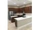 Modern kitchen features stainless steel appliances, granite countertops, and dark wood cabinetry at 1214 Godavari Way, Wesley Chapel, FL 33543