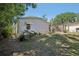 View of the backyard with mature trees and partial home view at 12519 Cambridge Ave, Tampa, FL 33624