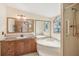 Bright bathroom featuring a large tub, spacious vanity and walk-in shower at 12519 Cambridge Ave, Tampa, FL 33624