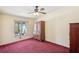 Bedroom with neutral walls, red carpeting, and a window providing natural light at 12519 Cambridge Ave, Tampa, FL 33624