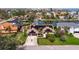 Aerial view of a canal-front home featuring solar panels, a two-car garage, and a well-manicured lawn at 137 11Th E St, Tierra Verde, FL 33715