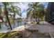 Well-manicured backyard with mature palm trees, canal view, and rock landscaping leading to the waterfront at 137 11Th E St, Tierra Verde, FL 33715