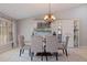 Refined dining space boasting a glass-top table, comfortable seating, modern chandelier and custom built-in cabinet at 137 11Th E St, Tierra Verde, FL 33715