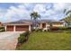 Beautifully landscaped single-story home with solar panels, a well-manicured lawn, and a spacious three-car garage at 137 11Th E St, Tierra Verde, FL 33715