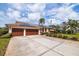 Charming home with solar panels, a well-manicured lawn, mature landscaping, and a spacious three-car garage at 137 11Th E St, Tierra Verde, FL 33715