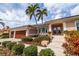 Charming home with a two-car garage, lush landscaping, and a welcoming front entrance with double doors at 137 11Th E St, Tierra Verde, FL 33715
