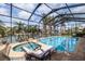 Inviting screened pool with a spa, sun loungers, and a lovely view of the canal at 137 11Th E St, Tierra Verde, FL 33715