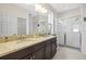 Bright bathroom featuring double vanity with granite countertops and a glass-enclosed shower at 1435 Montgomery Bell Rd, Wesley Chapel, FL 33543