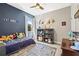 Bright bedroom with a blue accent wall, a bookshelf, and a cozy bed at 1435 Montgomery Bell Rd, Wesley Chapel, FL 33543