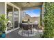 Relaxing covered patio with a ceiling fan, outdoor dining set, and lush greenery, creating a tranquil outdoor space at 1435 Montgomery Bell Rd, Wesley Chapel, FL 33543