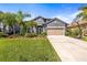 Charming single-Gathering home with lush landscaping, featuring a two-car garage and a basketball hoop at 1435 Montgomery Bell Rd, Wesley Chapel, FL 33543