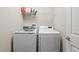 Functional laundry room equipped with a washing machine, dryer, and wire shelving at 1435 Montgomery Bell Rd, Wesley Chapel, FL 33543