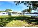 Large backyard with a well-manicured lawn, white fencing and mature trees offering plenty of space and privacy at 1509 Lemon St, Clearwater, FL 33756
