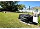 Expansive backyard with lush green grass, mature trees, patio seating and a grill, perfect for outdoor enjoyment at 1509 Lemon St, Clearwater, FL 33756