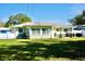 Backyard of home with green lawn, dining set on patio, and mature trees providing shade at 1509 Lemon St, Clearwater, FL 33756