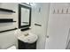 Compact bathroom features a vanity with sink, modern shelving and decorative wall hooks at 1509 Lemon St, Clearwater, FL 33756