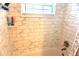 Shower with white marble tile, built-in corner shelves, and a window for natural light at 1509 Lemon St, Clearwater, FL 33756