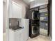 Convenient laundry area with stacked washer and dryer, utility sink, and storage at 15904 Redington Dr, Redington Beach, FL 33708