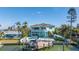 The home's rear exterior has a balcony, stairs, pool, and waterfront views, ideal for relaxing by the water at 15904 Redington Dr, Redington Beach, FL 33708