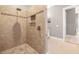 Walk-in shower with river rock floor and accent, with neutral toned tile at 15904 Redington Dr, Redington Beach, FL 33708