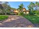 Elegant exterior view of a Mediterranean-style home showcasing a circular brick driveway and lush landscaping at 16205 Sierra De Avila, Tampa, FL 33613